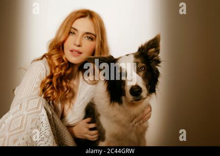 Blond woman at home in pijama with a border collie dog Stock Photo