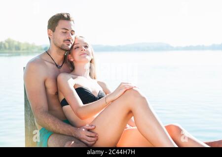 Portrait of young couple ralaxing together on jetty Stock Photo