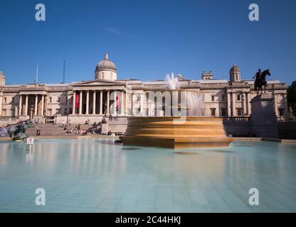 LONDON, UK - 18TH JULY 2015: Trafalgar Square in London during the day. People and the National Gallery can be seen. Stock Photo