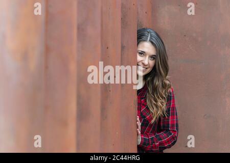 Portrait of smiling young woman wearing red plaid shirt Stock Photo