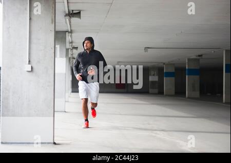 Young man running in a car park Stock Photo