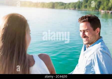 Young couple relaxing in front of a lake Stock Photo