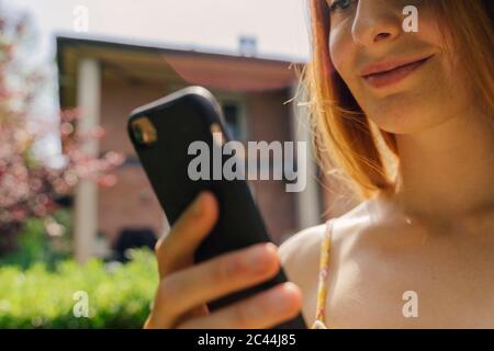 Young woman using smart phone at garden Stock Photo