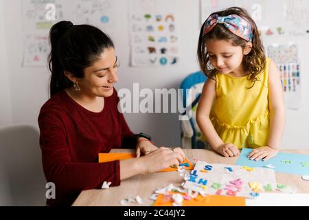 Mother and daughter doing crafts at home Stock Photo