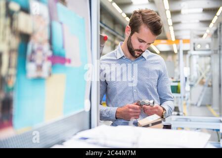 Man examining workpiece in a factory Stock Photo