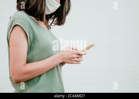 Woman wearing protective mask using cell phone Stock Photo