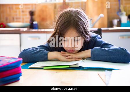 Girl doing homework in kitchen at home Stock Photo