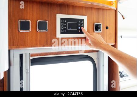 Hand of man pressing button on motor home control panel Stock Photo