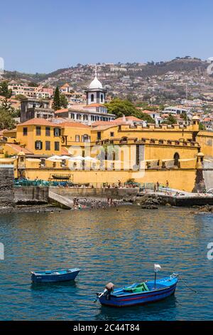 Portugal, Madeira Island, Funchal, View of Forte de Sao Tiago with fishing boats in foreground Stock Photo