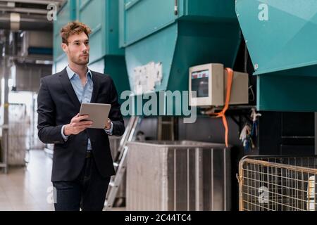 Young businessman holding tablet in a factory Stock Photo