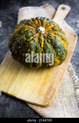 Pumpkin on wooden cutting board Stock Photo