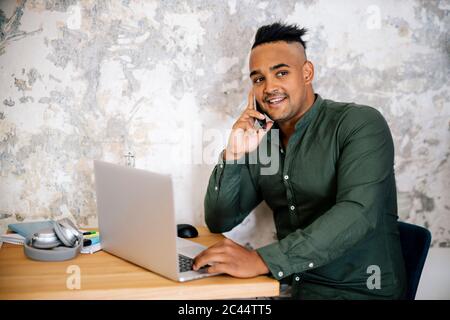 Portrait of young man on the phone working at home office Stock Photo