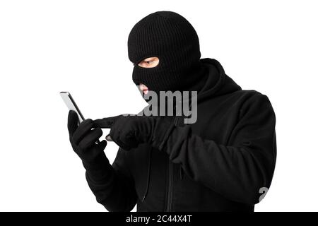 Masked villain touching a smart phone screen Stock Photo