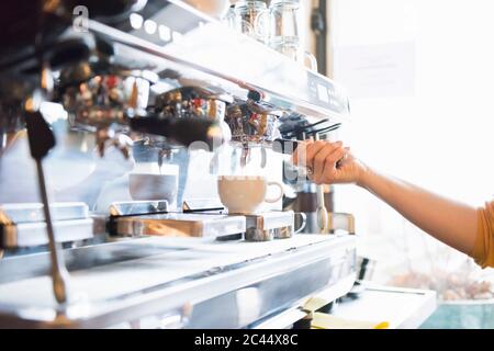 Hand of female barista using espresso maker in coffee shop Stock Photo