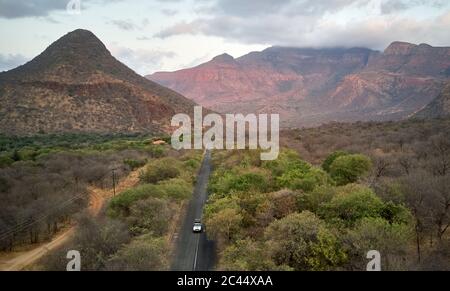 Aerial view of 4x4 vehicle on road against mountains Stock Photo