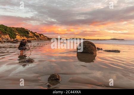 New Zealand, Oceania, South Island, Southland, Hampden, Otago, Moeraki, Koekohe Beach, Moeraki Boulders Beach, Moeraki Boulders, Round stones on beach at sunrise Stock Photo