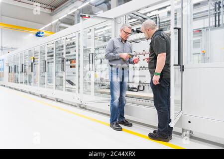 Two men talking in a factory Stock Photo