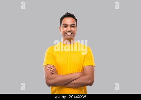 Indian Man Standing Hands Crossed Smiling in Yellow Tshirt Isolated Stock Photo