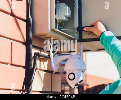 technician female setup cctv camera on wall Stock Photo