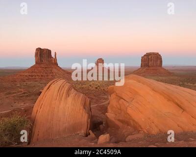 Amazing view of Monument Valley with red desert and blue sky and clouds in the morning. Monument Valley in Arizona with West Mitten Butte, East Mitten Stock Photo