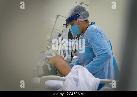Sao Paulo, Brazil. 23rd June, 2020. A medical assistant is treating a patient in the public hospital of Parelheiros. The number of corona deaths in Brazil is over 50,000. Credit: Lincon Zarbietti/dpa/Alamy Live News Stock Photo