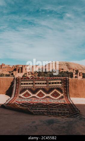 Vertical closeup shot of a patterned carpet with a landscape on the background Stock Photo