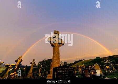 Double rainbow at sunset over graveyard, cemetery of The Church of the Holy Family, Ardara, County Donegal, Ireland Stock Photo