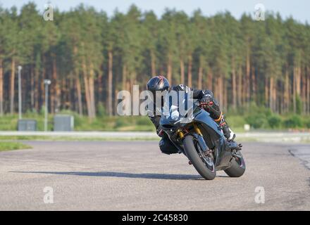 12-06-2020 Riga, Latvia. Fast motorbike racing on the race track at high speed. Composite image with heavy image editing Stock Photo