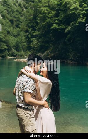 Young couple in the nature. A man hugs a woman. They are going to kiss. Stock Photo