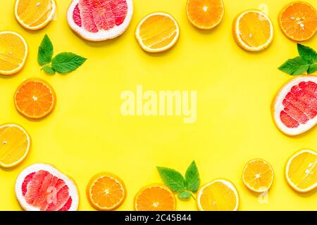 Frame sliced citrus mix yellow background top view Stock Photo