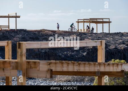 People walking and cycling on the new pedestrian walkway from Los Abrigos to Golf del Sur where it passes San Blas, Tenerife, Canary Islands, Spain Stock Photo