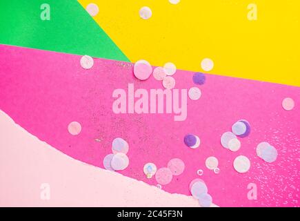 Colorful confetti, sparkles on bright pink, pastel pink, yellow and green background. Festive background. Stock Photo