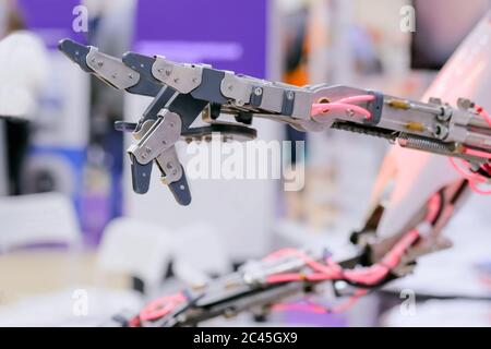 Close up shot of futuristic robotic hand showing devil horns rock metal sign symbol gesture at technology exhibition. Future, science and robotic Stock Photo
