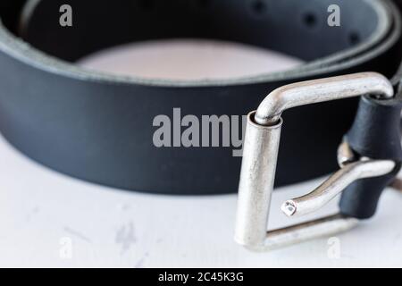 Leather belt for trousers on a white table. Haberdashery. Belt with a metal buckle. Stock Photo