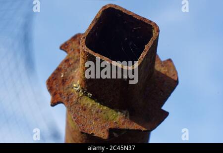 Closeup on a rusty carpet roll display bar and cogs. square open end, blue sky Stock Photo
