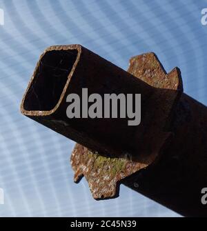 Closeup on a rusty carpet roll display bar and cogs. square open end, blue sky Stock Photo
