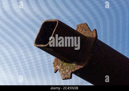 Closeup on a rusty carpet roll display bar and cogs. square open end, blue sky Stock Photo