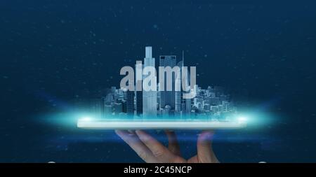 Hand holding digital tablet with urban cityscape hologram over screen Stock Photo