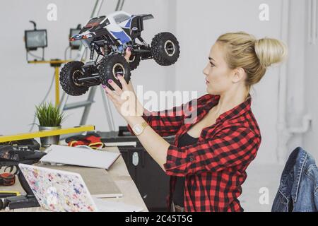 Woman examining radio-controlled car in workshop Stock Photo