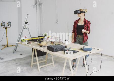 Woman using virtual reality goggles in workshop Stock Photo