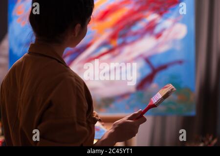 Artist admiring latest masterpiece in art workshop. Modern artwork paint on canvas, creative, contemporary and successful fine art artist drawing masterpiece Stock Photo