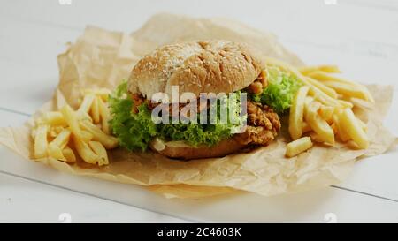 French fries and burger on parchment Stock Photo