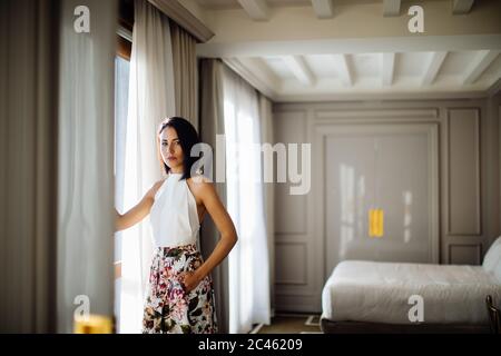 Fashionable woman beside window in suite Stock Photo