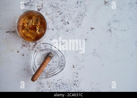 Whiskey or brandy in a glass with Cuban cigar Stock Photo