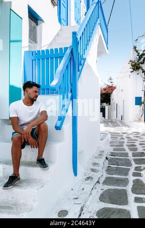 young guy on vacation at the Greek Island of Mykonos, men relaxing at the little venice village of Mykonos Island Stock Photo