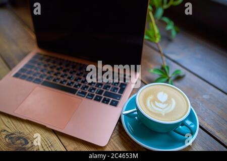 office stuff with laptop and coffee cup on wooden table. Stock Photo