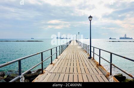 Perspective of the long walking pier by the sea in Limassol, Cyprus - Landscape Stock Photo