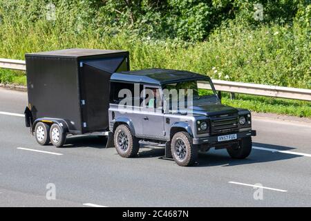 2007 Image 4x4 modified black grey off-roader Land Rover Defender 90 Hard Top; Vehicular traffic moving vehicles, driving vehicle on UK roads, motors, motoring with trailer on the M6 motorway highway Stock Photo