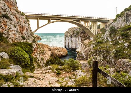 The Ciolo bridge connects two high cliffs. An inlet of the sea, in Gagliano del Capo, near Santa Maria di Leuca. The red and orange sunset. On a winte Stock Photo