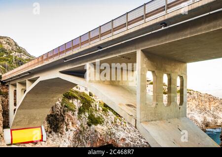 The Ciolo bridge connects two high cliffs. An inlet of the sea, in Gagliano del Capo, near Santa Maria di Leuca. The red and orange sunset. On a winte Stock Photo